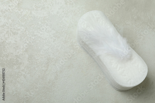 Stack of sanitary pads on white textured background