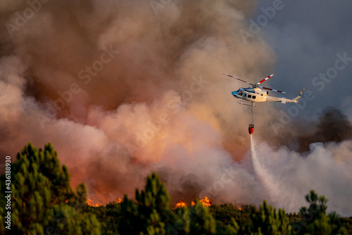 Spectacular helicopter with bambi bucket over the fire