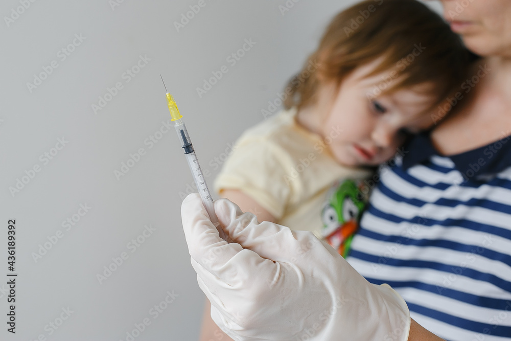 A doctor makes a vaccination to a child A doctor makes a vaccination to a child