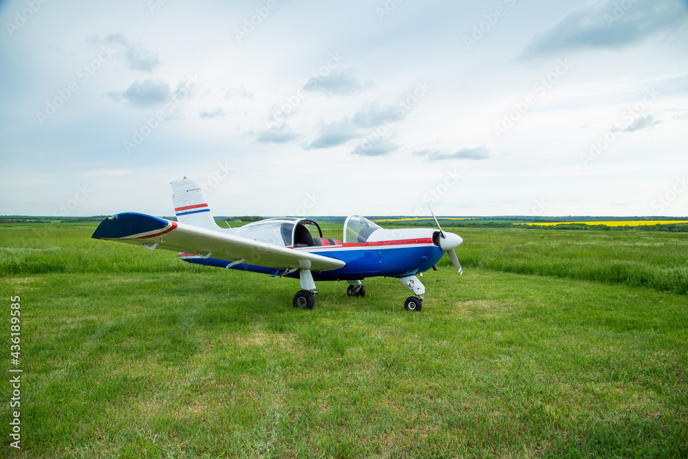 Walking small propeller plane on a green field Walking small propeller plane on a green field