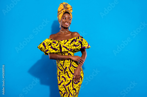 Photo of young stunning beautiful charming african woman look copyspace wear turban isolated on blue color background photo