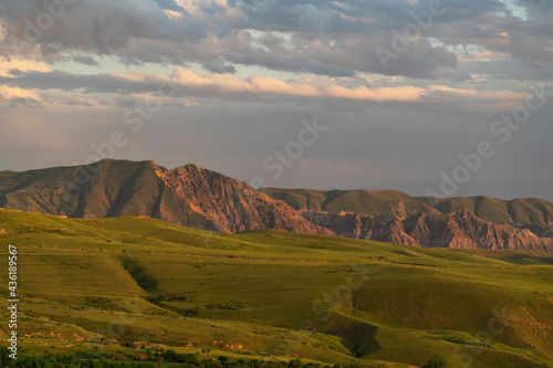 Beautiful summer landscape, panoramic green field and. mountains after sunset.