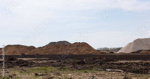 Mountains of sand and rubble. Before starting the construction of a new road. Panorama. The background.
