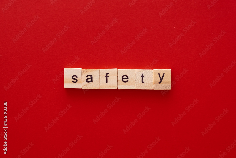 word SAFETY made of wooden letters on red background with copy space