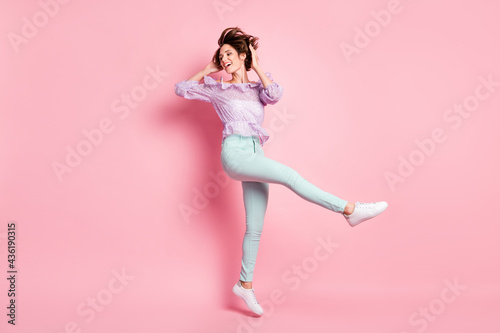 Full size photo of young beautiful happy excited smiling cheerful girl jumping isolated on pink color background