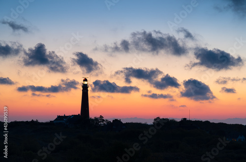 Lighthouse in the dunes and clouds during a nice sunset.