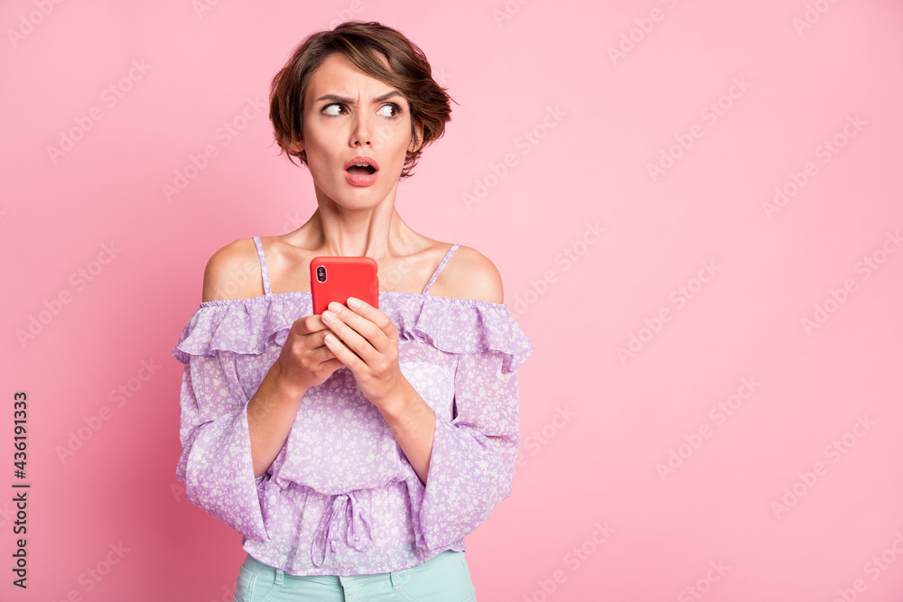 Photo of young shocked amazed surprised girl using smartphone look copyspace isolated on pink color background Photo of young shocked amazed surprised girl using smartphone look copyspace isolated on pink color background