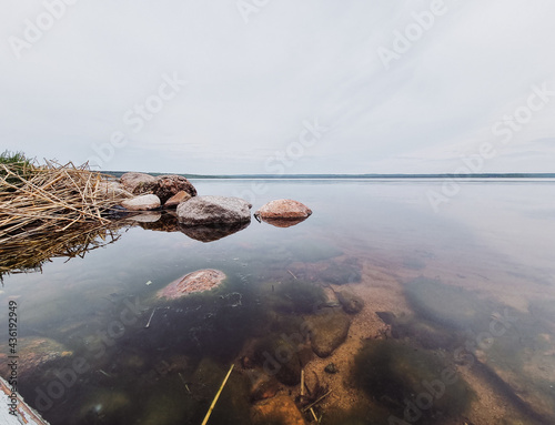 Scenic view of a lake in a forest with calm water on a cloudy day.