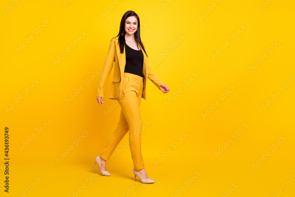 Full size profile side photo of young attractive woman happy positive smile go walk step isolated over yellow color background