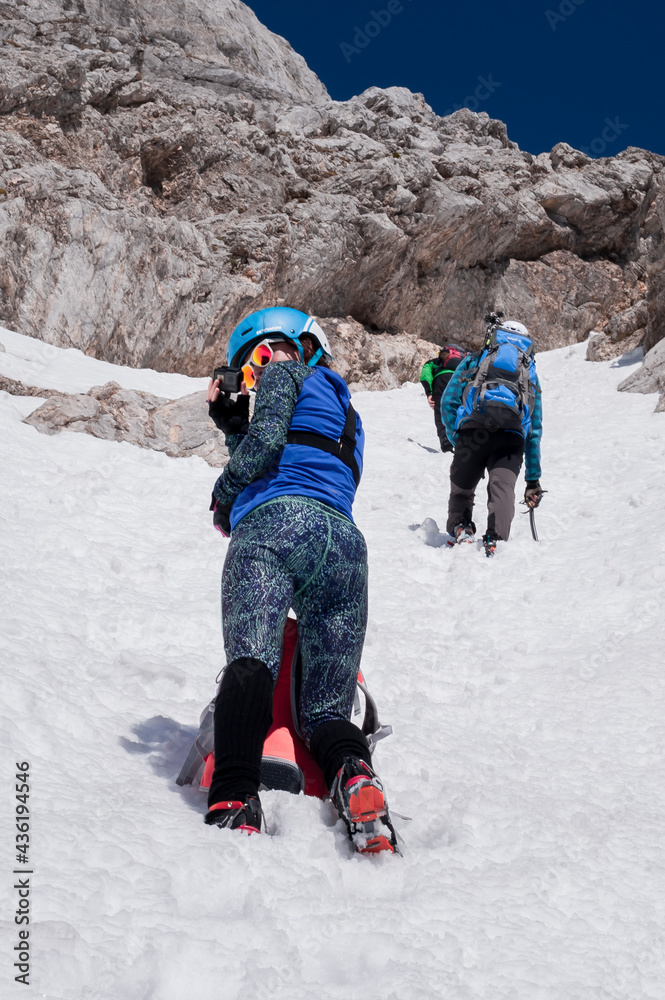 beautiful sporty girl climber takes photos on a small camera from the top of the conquered peak beautiful sporty girl climber takes photos on a small camera from the top of the conquered peak