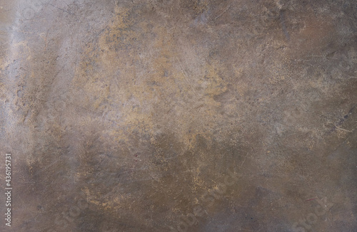 The texture of the worn bronze background is covered with a patina 