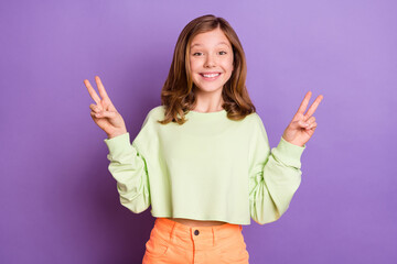 Photo of young excited girl happy positive smile show peace cool v-sign greetings isolated over violet color background