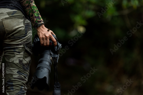 Close up hand and butterfly. Professional photographer woman holding camera for taking butterfly in the green jungle rain forest nature. Travel and Vacations Concept