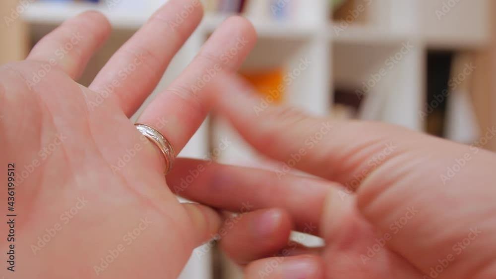 Man puts on a wedding ring on his finger hands closeup Man puts on a wedding ring on his finger hands closeup