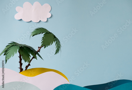 Fototapeta Naklejka Na Ścianę i Meble -  Two palm trees on a sandy island under the sun in the sea with paper waves.