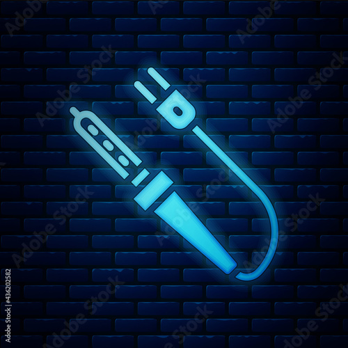 Glowing neon Soldering iron icon isolated on brick wall background. Vector