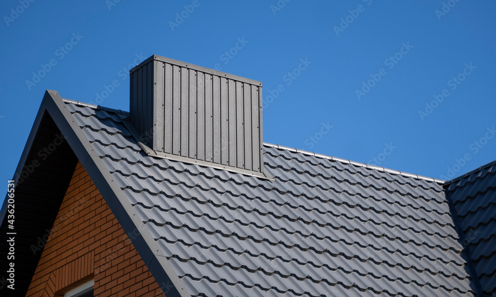 Grey corrugated metal profile roof installed on a modern house. The roof of corrugated sheet. Roofing of metal profile wavy shape. Modern roof made of metal. Metal roofing. Grey corrugated metal profile roof installed on a modern house. The roof of corrugated sheet. Roofing of metal profile wavy shape. Modern roof made of metal. Metal roofing.