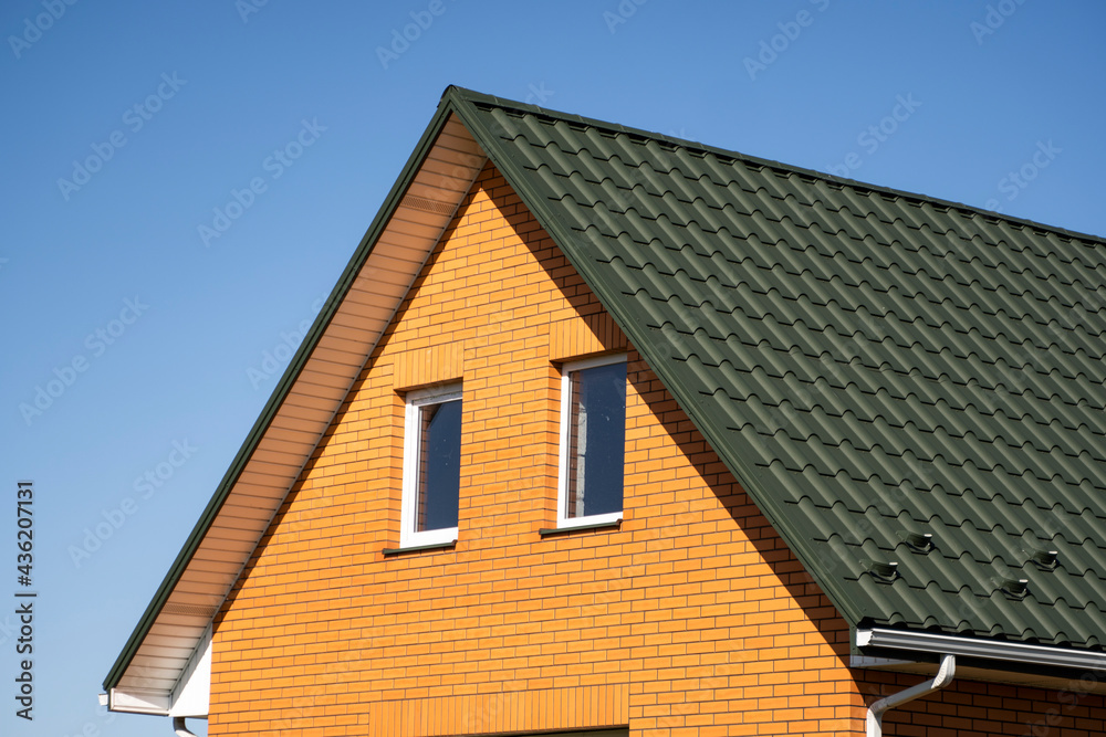 Green corrugated metal profile roof installed on a modern house. The roof of corrugated sheet. Roofing of metal profile wavy shape. Modern roof made of metal. Metal roofing.