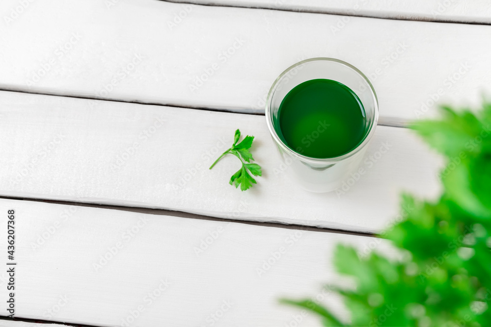 Top view of chlorophyll water in a glass on white wooden table with copy space - obrazy, fototapety, plakaty 