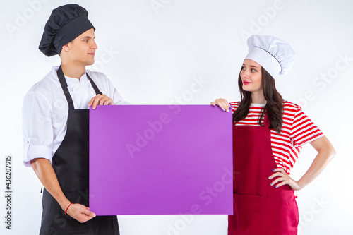 Two chefs cooks show a blan...