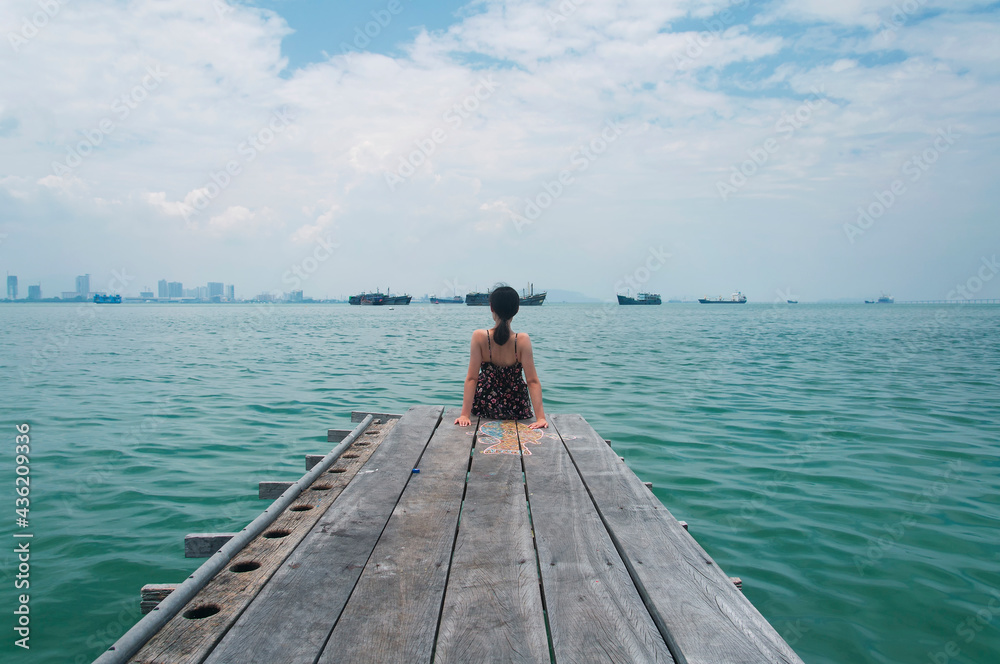 Chinese woman sitting on a jetty in Penang malaysia Chinese woman sitting on a jetty in Penang malaysia