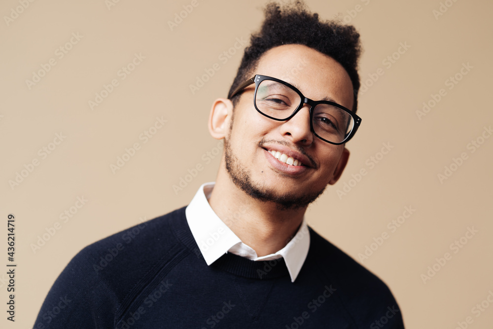 Young handsome man wearing sweater, white shirt and glasses over beige background face smiling looking at the camera. Positive person, professor style Young handsome man wearing sweater, white shirt and glasses over beige background face smiling looking at the camera. Positive person, professor style
