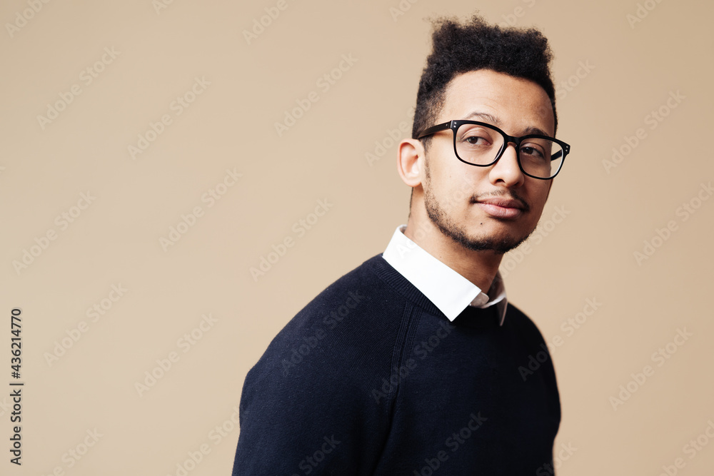 Young handsome man wearing sweater, white shirt and glasses over beige background face smiling looking at the camera. Positive person, professor style Young handsome man wearing sweater, white shirt and glasses over beige background face smiling looking at the camera. Positive person, professor style
