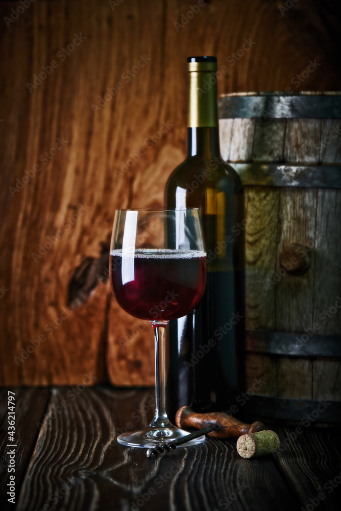 Wine bottle, Wine Cask, wine glass with a corkscrew and a cork stopper shot on rustic textured wooden table.