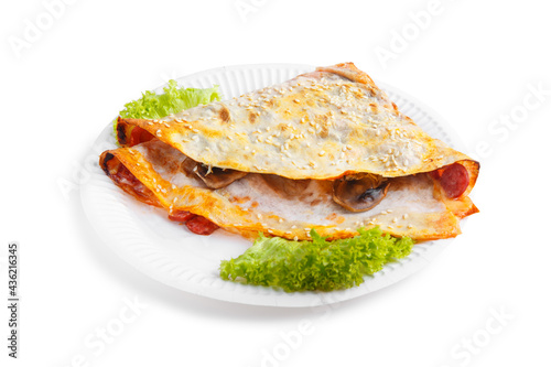 Frozen pancakes stuffed with meat on plate. Isolated on white background
