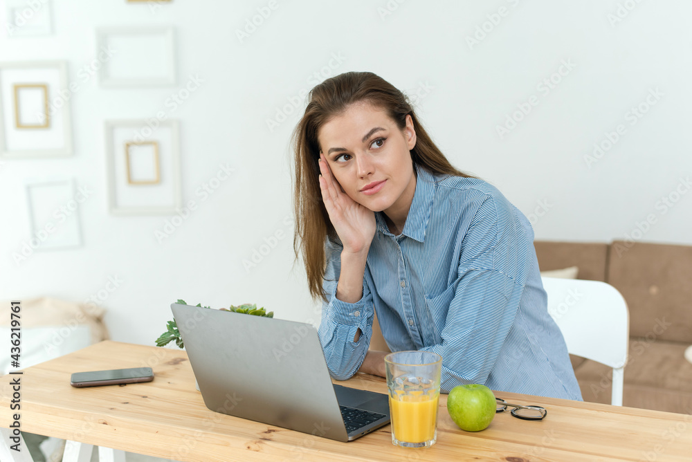 Student thinking while doing complicated homework on line with a laptop at home. Photo of young pretty businesswoman sit indoors in office using laptop computer staring thoughtfully into the air Student thinking while doing complicated homework on line with a laptop at home. Photo of young pretty businesswoman sit indoors in office using laptop computer staring thoughtfully into the air