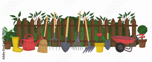 Garden illustration in flat style isolated on white background. Brown wooden fence with green bushes, potted flowers, trees, watering can, rubber boots, broom, shovels, pitchfork, cart 