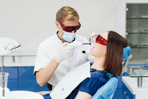 Close-up portrait of a female patient visiting dentist for teeth whitening in clinic