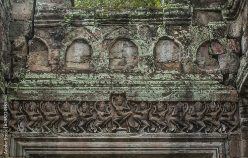 A carvings of lintels on a stone, women standing in line, showing dancing in verb raising right foot, flirting with both hands at Preach castle. Khan, Cambodia