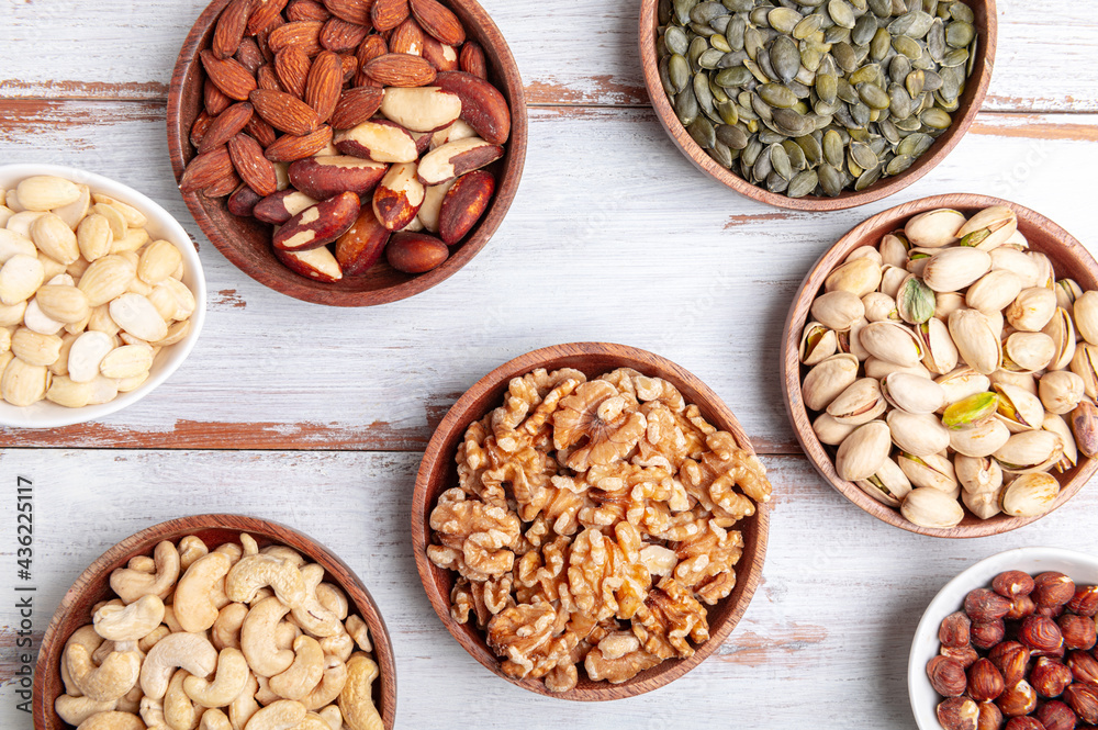 Different kind of nuts in wooden bowls Different kind of nuts in wooden bowls