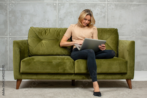 Young attractive blonde woman at home with laptop