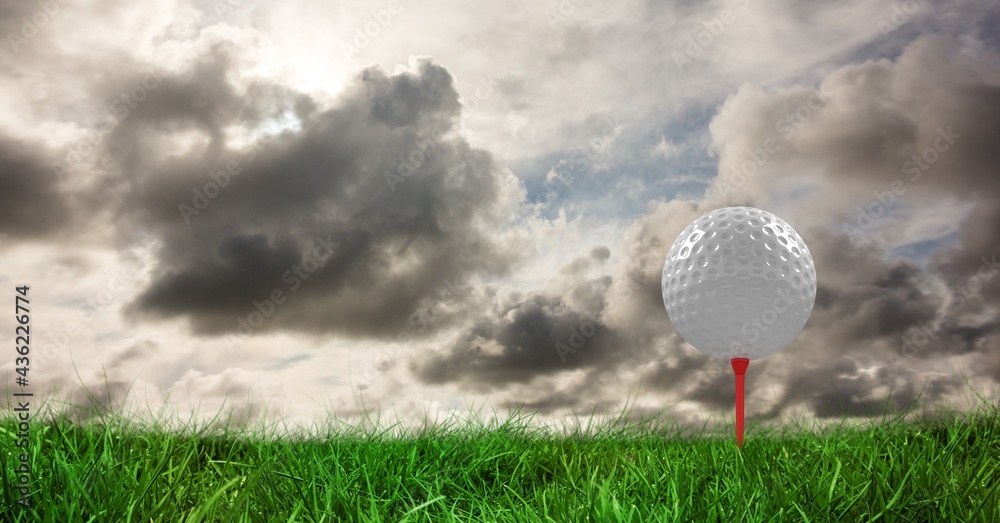 Composition of golf ball in grass on red tee, clouds, and copy space Composition of golf ball in grass on red tee, clouds, and copy space