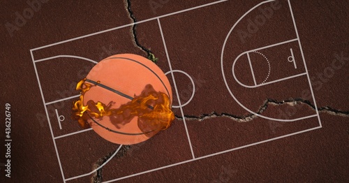 Composition of basketball on fire over cracked basketball court