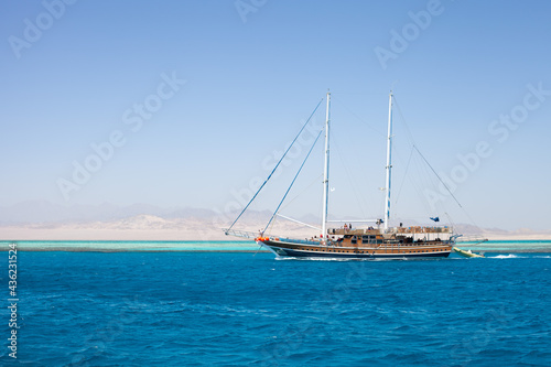 Billede på lærred Imitation of a pirate ship with lowered sails, pleasure boat, Red sea and Sinai mountains on a background