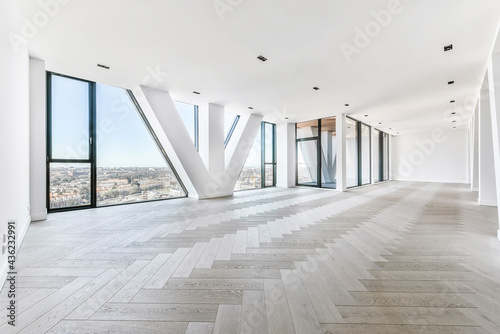 Spacious studio apartment with parquet flooring and panoramic windows viewing city in penthouse apartment