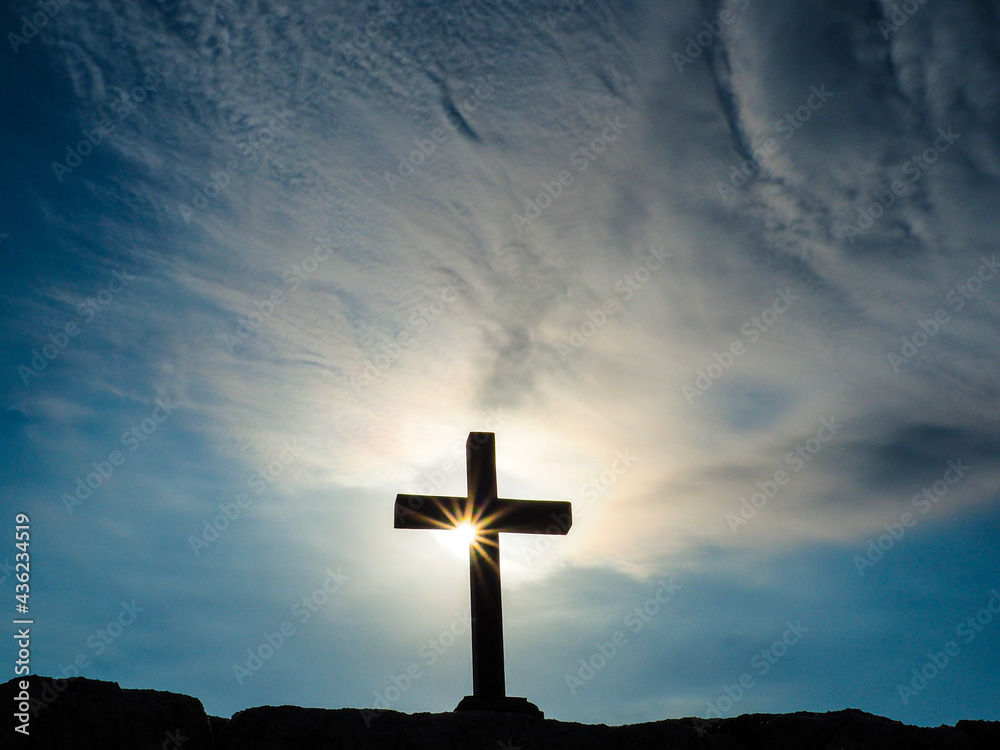 Silhouette crucifix on rock with sun ray starburst effect. Concept ...