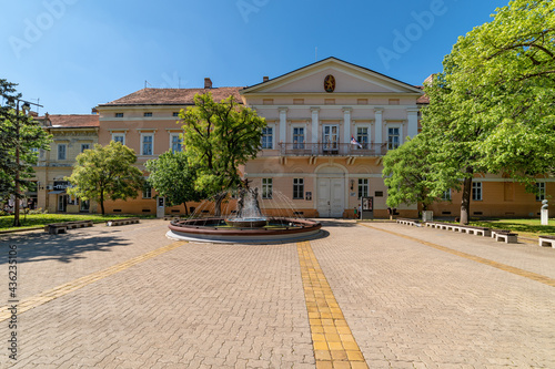 Kikinda, Serbia - May 04,2021: National Museum building and beautiful fountain with sculpture "Family" in Kikinda, Serbia