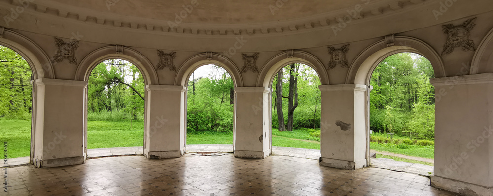 Music Pavilion from the inside, through the arches you can see the trees and grass in the park on Elagin Island in St. Petersburg.