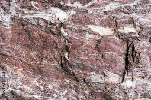 Rot weißer Naturstein mit sehr grober Oberfläche in Nahaufnahme