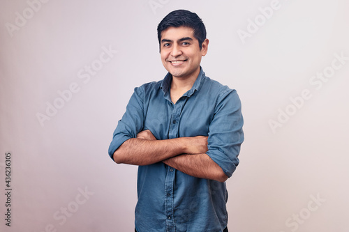 Hombre joven y feliz sonriendo en primer plano. Modelo aislado en fondo blanco con camisa azul photo