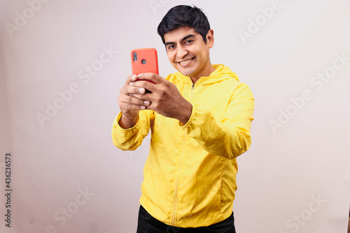 Hombre joven y feliz tomando una foto selfie mientras sonrie. Modelo aislado en fondo blanco  photo
