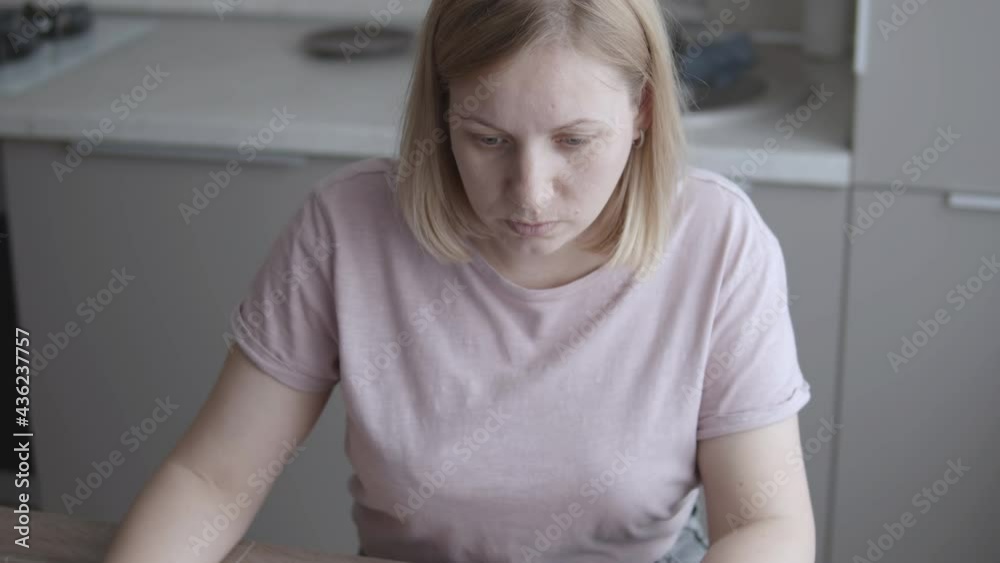 Girl uses laptop at home in the kitchen Girl uses laptop at home in the kitchen