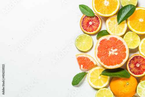 Citrus fruits at white background. Orange  lemon  lime  grapefruit with green leaves. Healthy food. Top view with copy space.