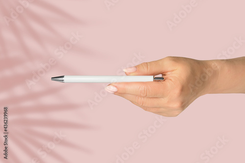 Pen in hand. Classic mock up for branding  sale and design on pink background