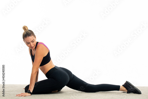 Young sportswoman stretching in studio