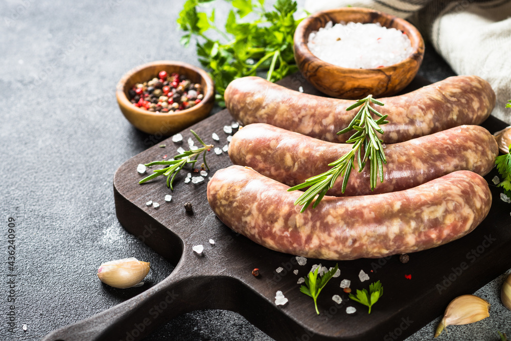 Bratwurst or sausages on cutting board with spices and herbs. Bratwurst or sausages on cutting board with spices and herbs.